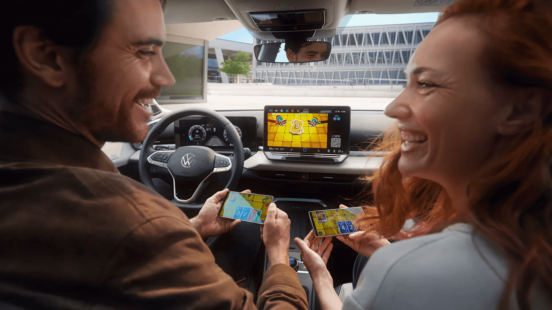 Pora žaidžia žaidimą savo telefonuose naudodama „Volkswagen T-Roc“ ekraną.