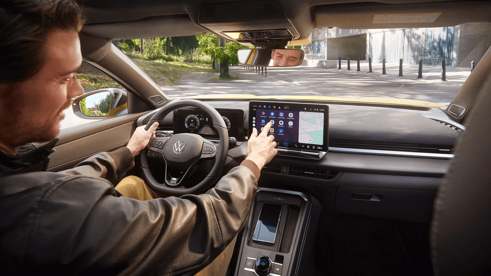 Vyras naudoja „Volkswagen T-Roc“ centrinį ekraną su navigacijos ir programėlių meniu.